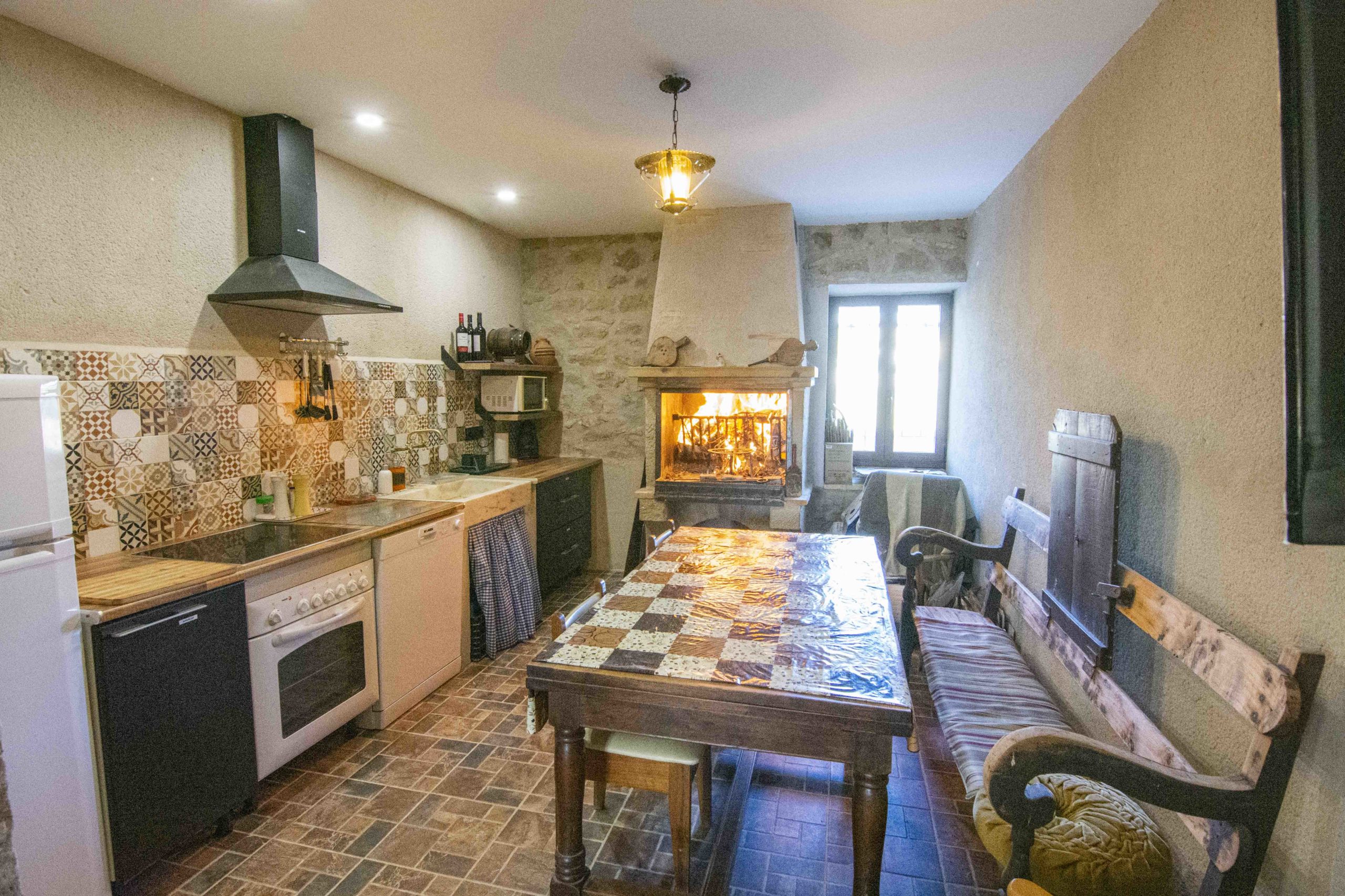 Foto del salón con cocina y chimenea en Casa Rural Borderías para disfrutar del turismo rural junto a la Sierra de Guara en Igriés